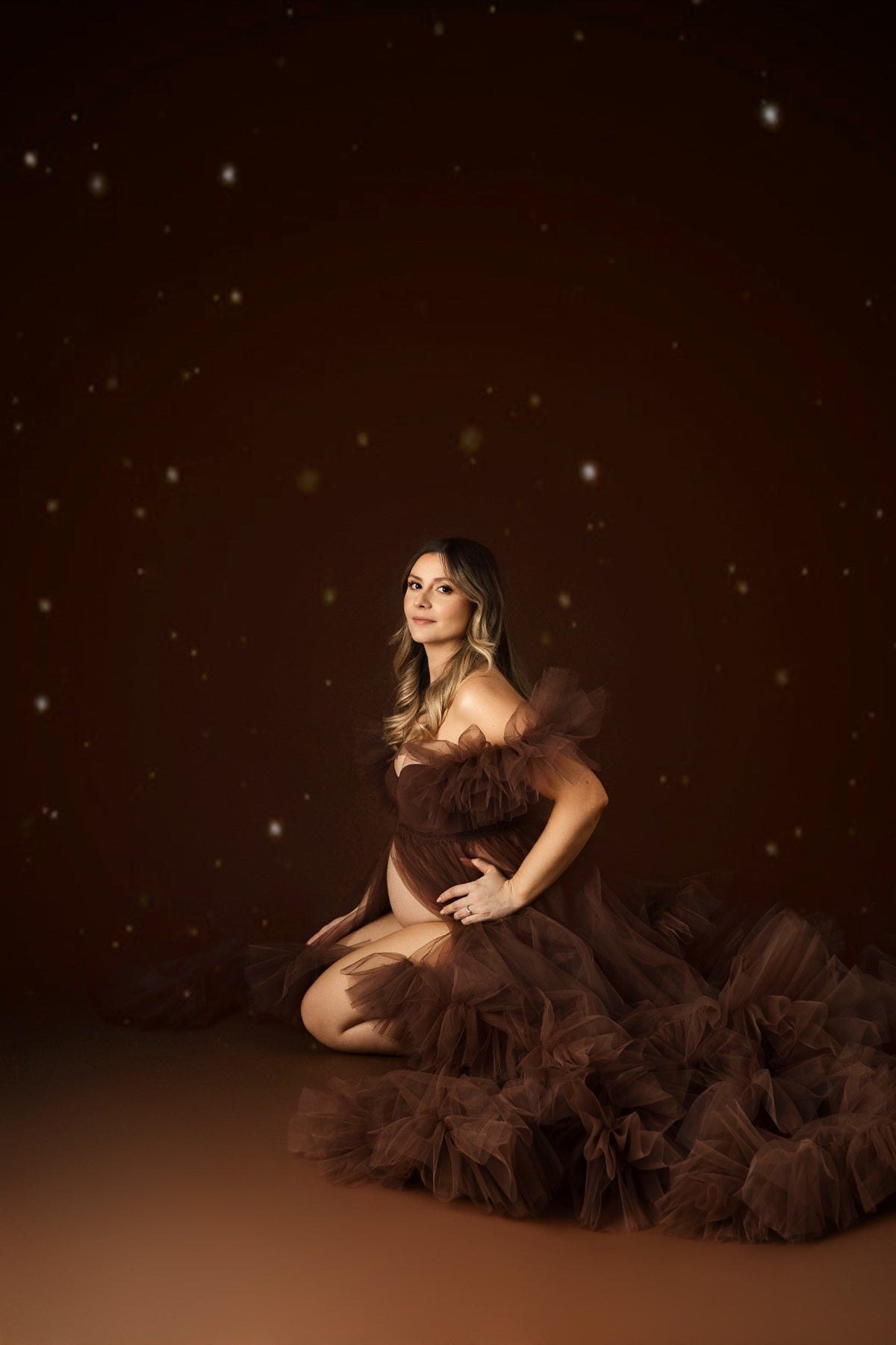 Portrait maternité artistique d'une future maman en robe brune