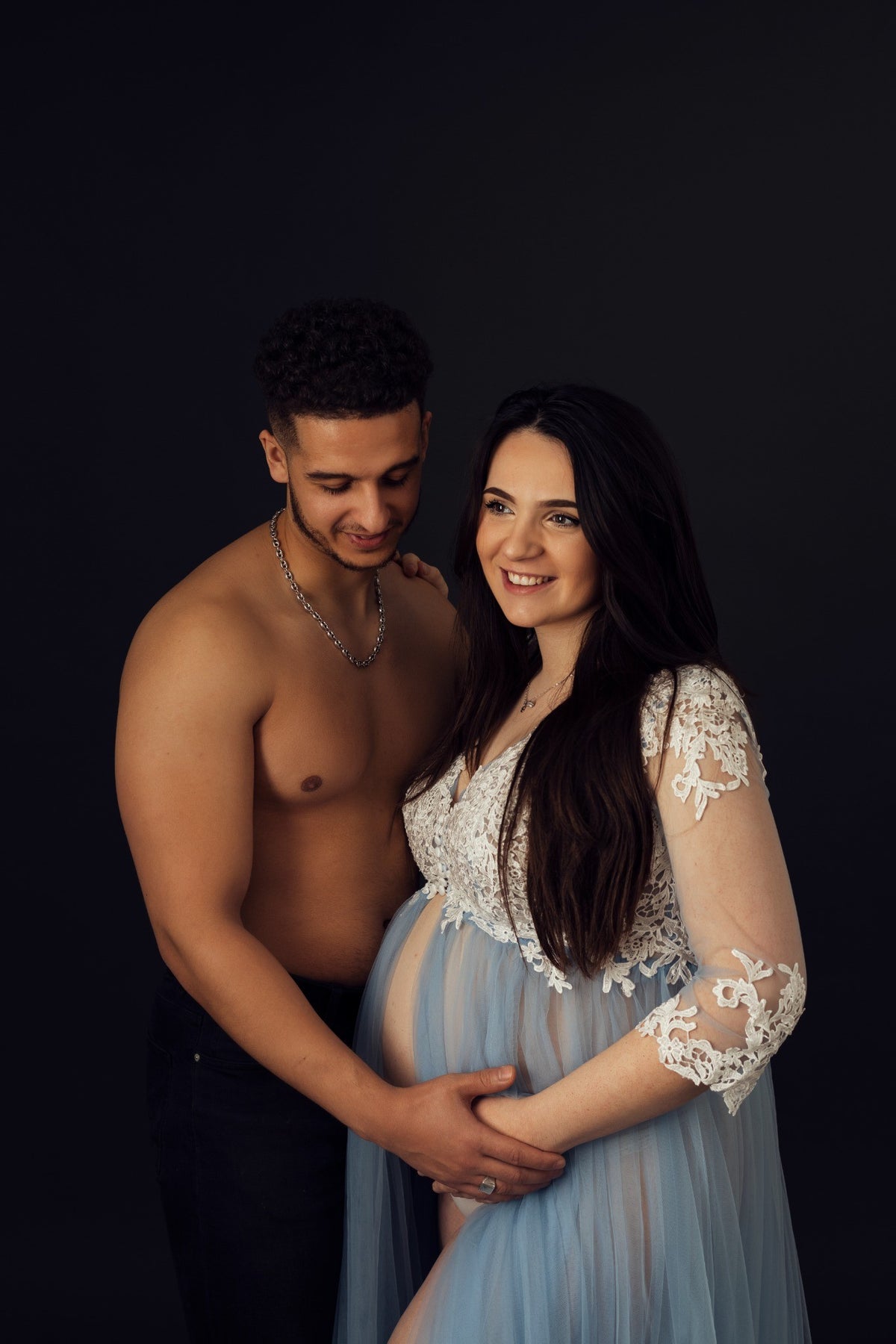 Future maman accompagnée du papa lors d'une séance grossesse