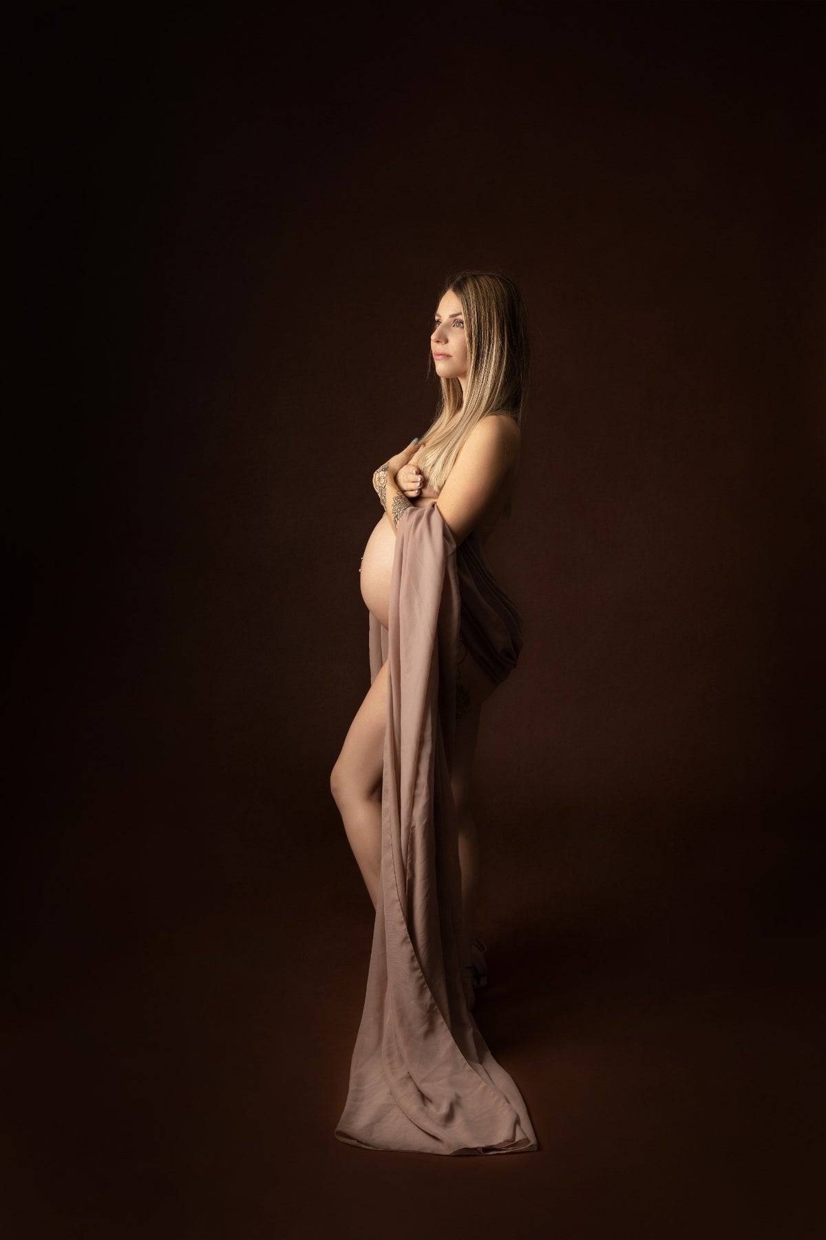 Future maman en robe fluide lors d'une séance grossesse