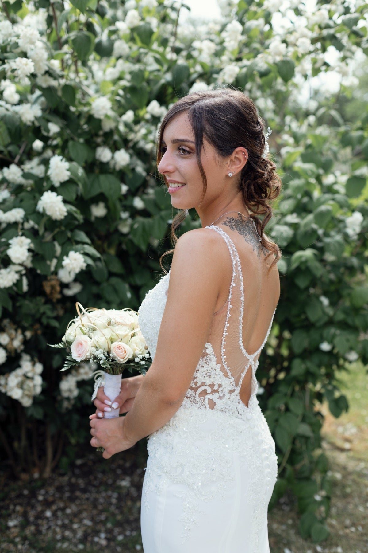 Portrait de la mariée avec son bouquet dans un jardin fleuri