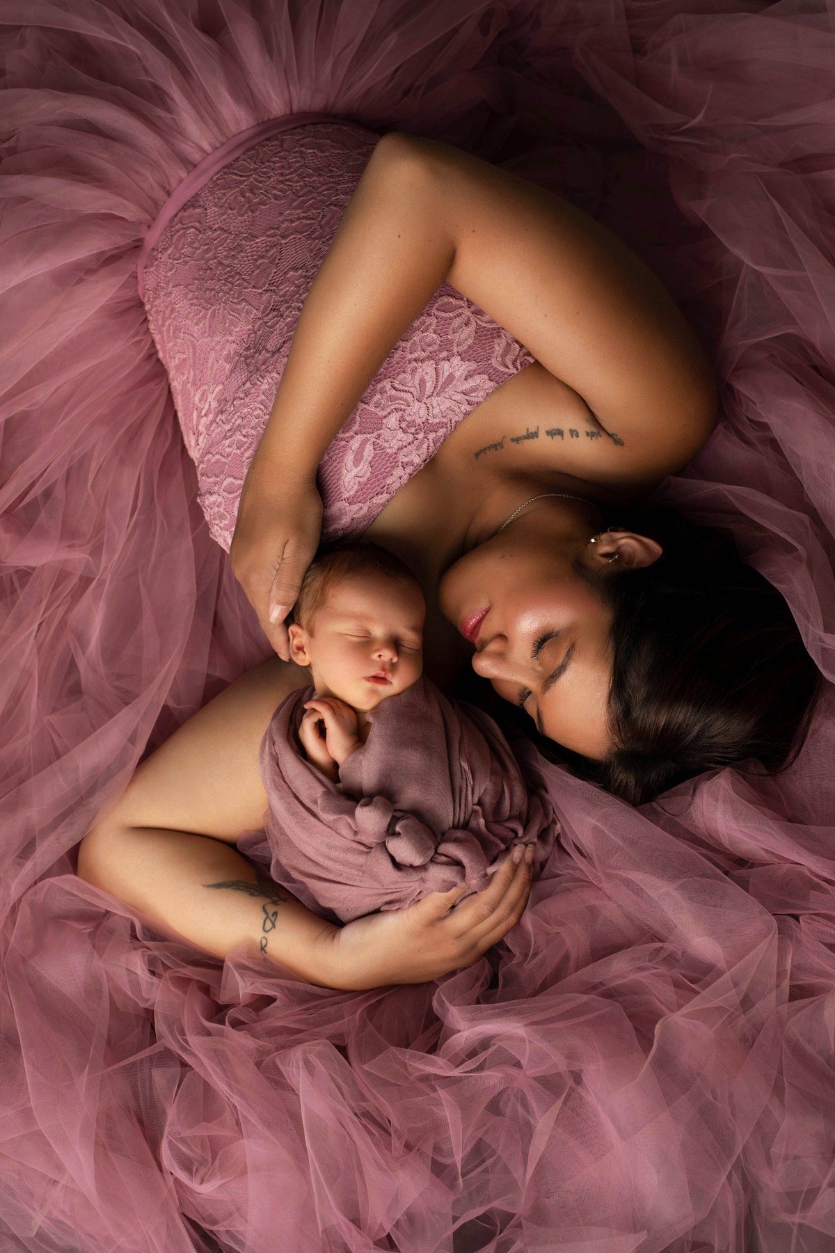 Maman avec son nouveau-né dans les bras lors d’une séance Naissance